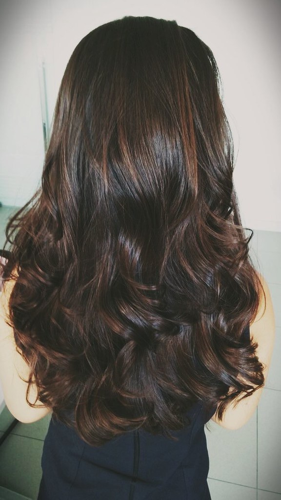 Back view of woman with beautiful brunette hair, with chocolate silk color. 